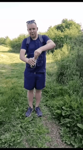 Man in Blue Shirt and Shorts Holding Soda