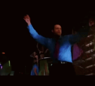 Man in Blue Shirt and Tie Dancing in Dark Room