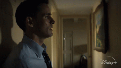 Man in Blue Shirt and Tie in Hallway With Disney Logo