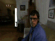 Man in Blue Shirt and Tie Standing in Dark Room With T