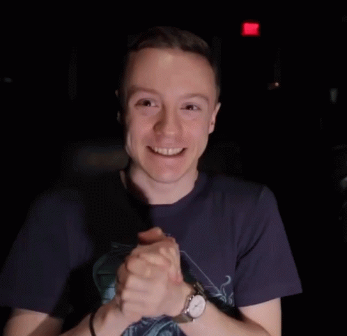 Man in Blue Shirt and Watch Smiling With Folded Hands