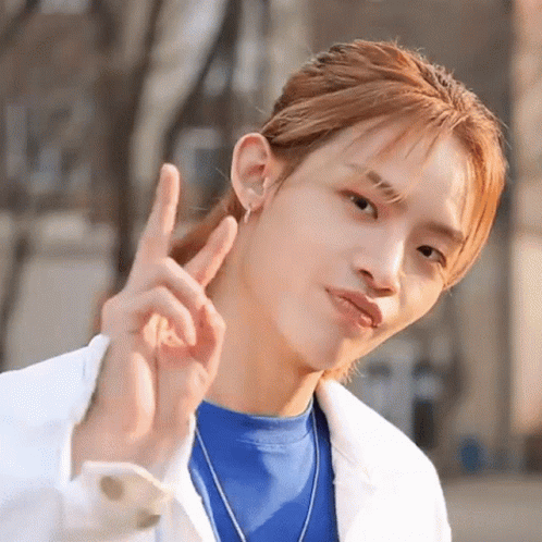 Man in Blue Shirt and White Jacket Making Peace Sign