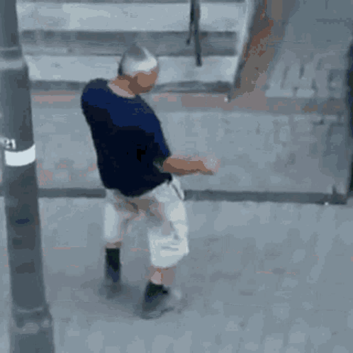 Man in Blue Shirt and White Shorts Walking on Street