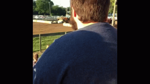 Man in Blue Shirt at Race Track