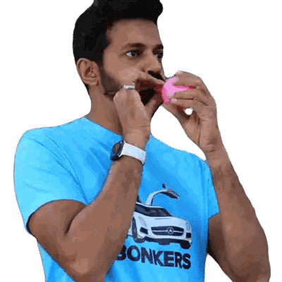 Man in Blue Shirt Blowing Up Pink Balloon