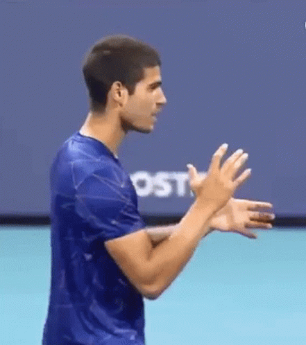 Man In Blue Shirt Clapping In Front Of Screen GIF