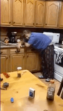 Man in Blue Shirt Cleaning Kitchen Cabinet