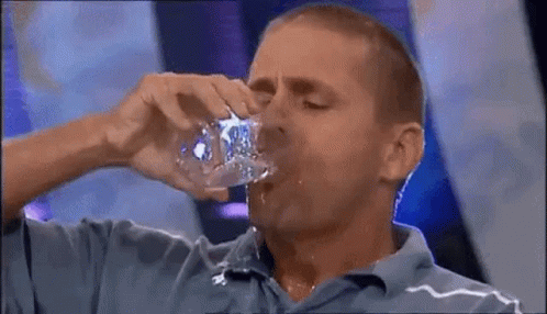 Man in Blue Shirt Drinking from Bottle