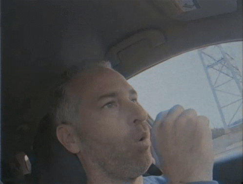 Man in Blue Shirt Driving Car Eyes Closed