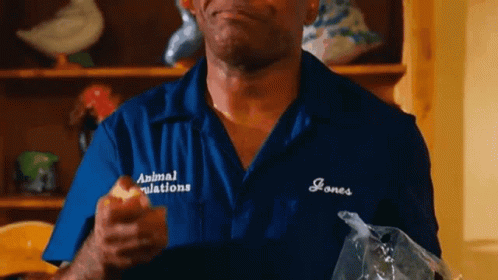 Man In Blue Shirt Eating Apple Holding Food Bag GIF