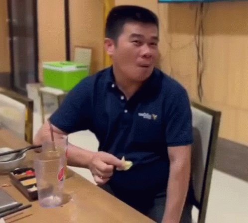 Man in Blue Shirt Eating Food