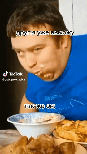 Man in Blue Shirt Eating from Bowl with Spoon