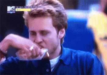 Man in Blue Shirt Eating Sandwich