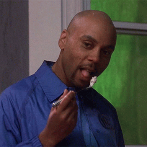 Man in Blue Shirt Eating with Tongue Out