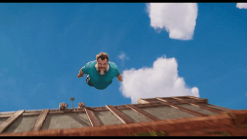 Man In Blue Shirt Flying Above Building GIF
