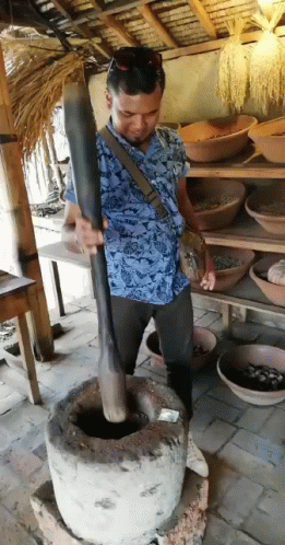 Man In Blue Shirt Grinding With Wooden Stick