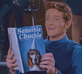 Man In Blue Shirt Holding Book Sensible Chuckle GIF