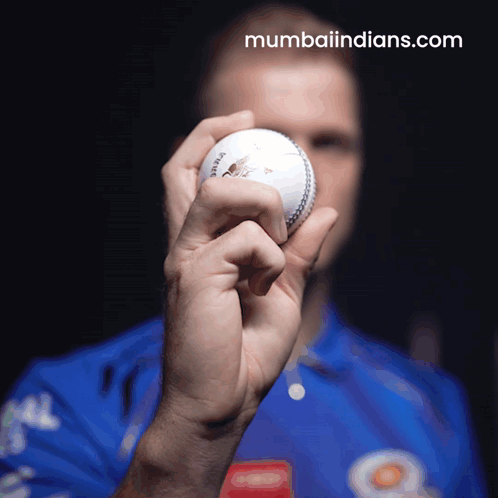 Man in Blue Shirt Holding Cricket Ball
