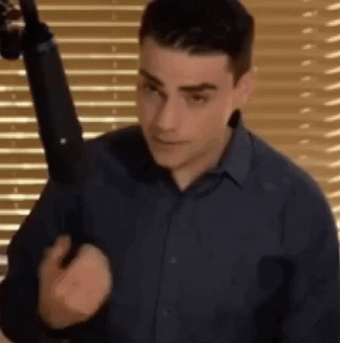 Man In Blue Shirt Holding Gun GIF
