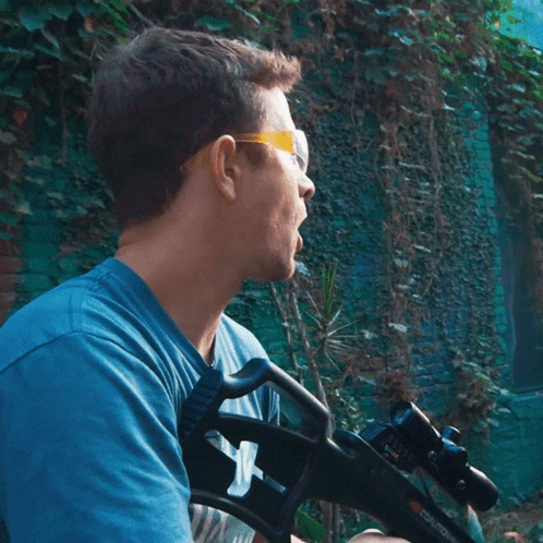 Man In Blue Shirt Holding Gun GIF
