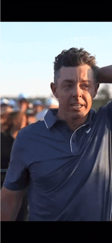 Man in Blue Shirt Holding Head