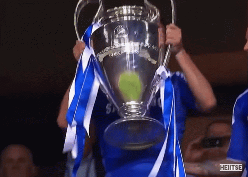 Man in Blue Shirt Holding Heitse Trophy