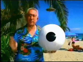 Man in Blue Shirt Holding Inflatable Ball With Eye