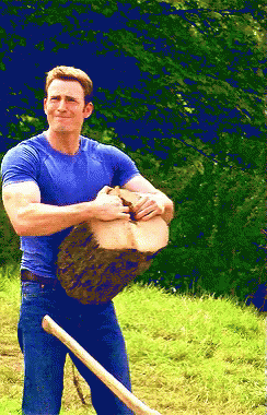Man in Blue Shirt Holding Log and Shovel