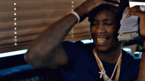 Man In Blue Shirt Holding Pile Of Money GIF