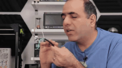 Man In Blue Shirt Holding Wire GIF