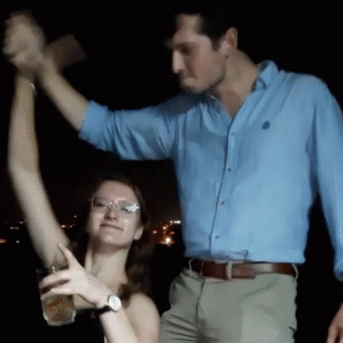 Man in Blue Shirt Holding Woman