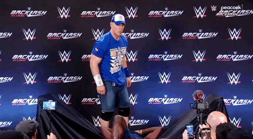 Man in Blue Shirt in Front of Backlash Wall