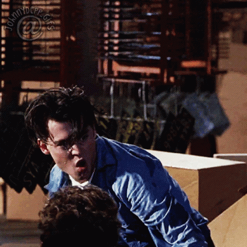 Man In Blue Shirt In Front Of Johnny Depp Sign GIF