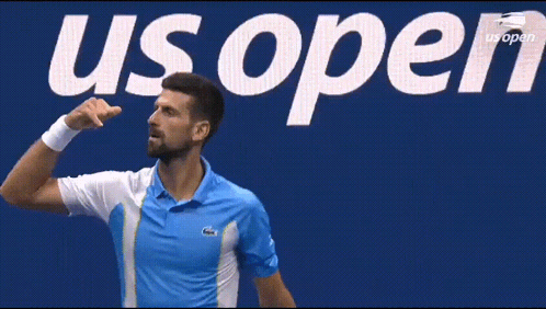 Man In Blue Shirt In Front Of US Open Sign GIF