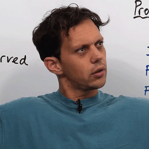 Man in Blue Shirt in Front of Whiteboard Saying Pro