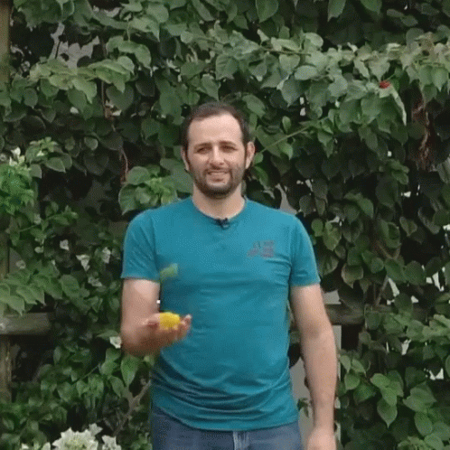 Man in Blue Shirt Juggling Ball on Head