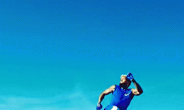 Man in Blue Shirt Jumping in the Air