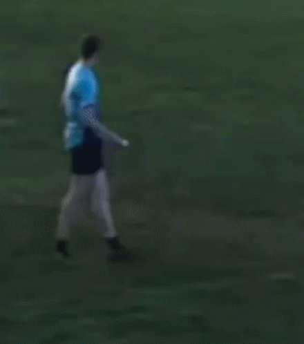 Man in Blue Shirt Kicking Frisbee