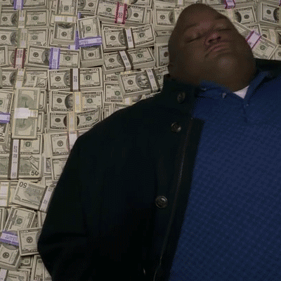Man In Blue Shirt Laying In Pile Of Money With 50 Bill GIF