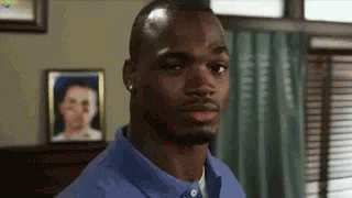 Man In Blue Shirt Looking At Camera With Woman Picture In Background GIF