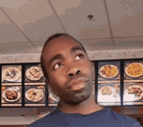 Man in Blue Shirt Looking at Menu