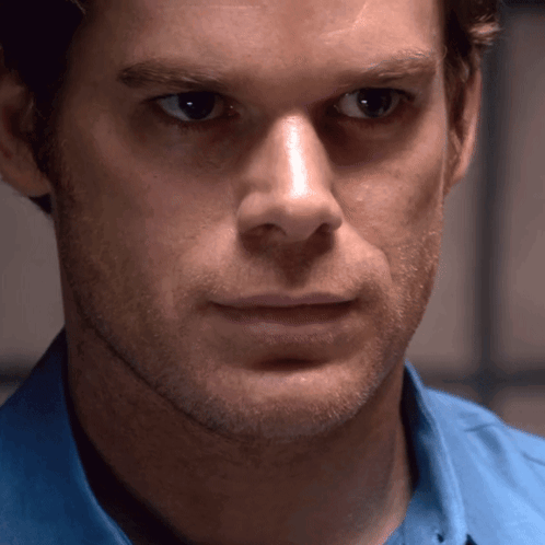 Man in Blue Shirt Looks at Camera