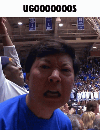 Man In Blue Shirt Making Funny Face In Front Of 2003 Banner GIF
