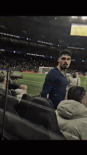 Man in Blue Shirt on Soccer Field Reach for the Sky