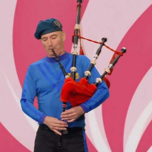 Man in Blue Shirt Playing Bagpipes
