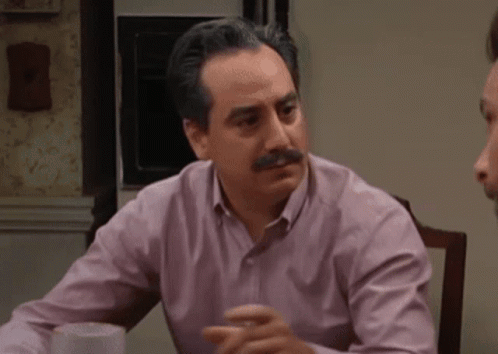 Man In Blue Shirt Pointing At Bulletin Board GIF