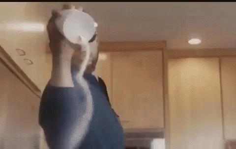 Man in Blue Shirt Pouring Milk Into Cup