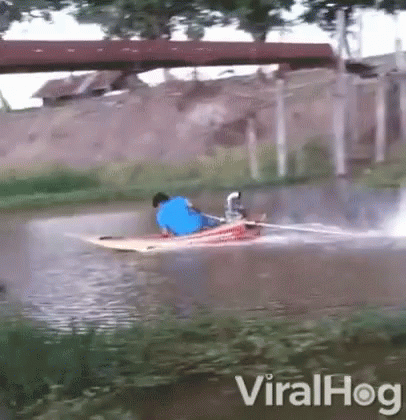 Man In Blue Shirt Riding Boat In River GIF