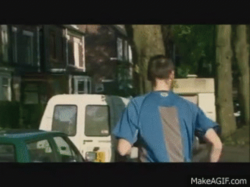 Man in Blue Shirt Running Down Street With Van