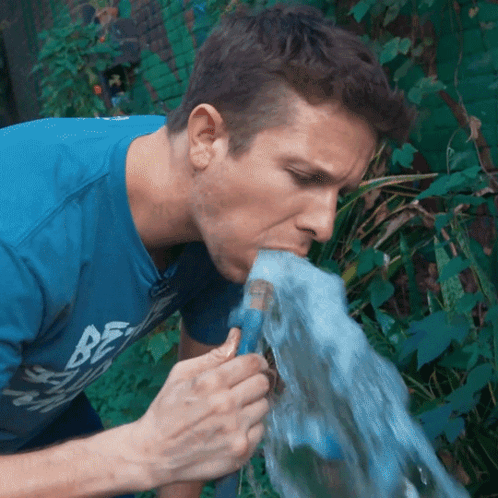 Man In Blue Shirt Saying Be Drinking Water From Hose GIF